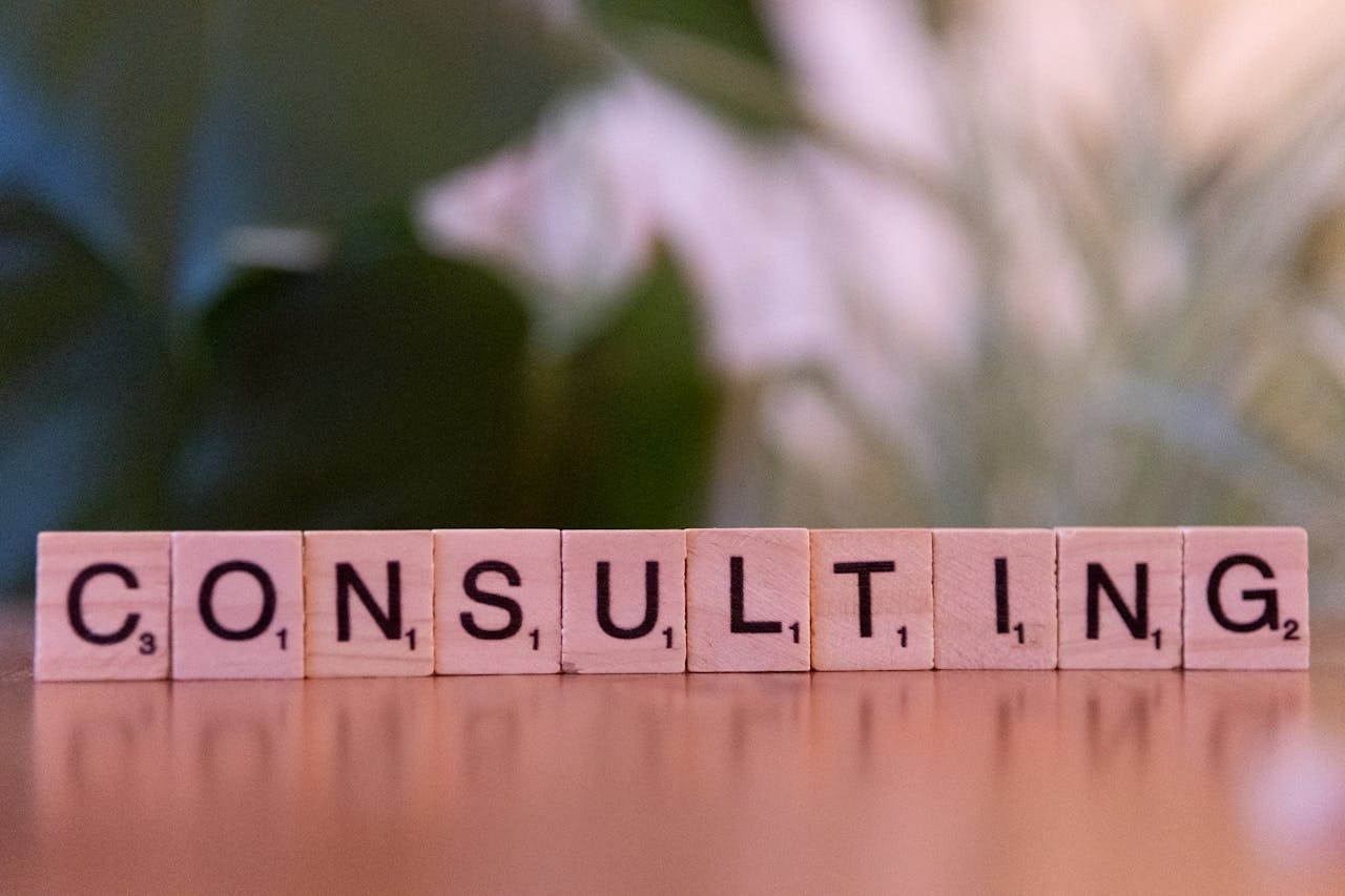 About Wooden letter tiles spelling 'Consulting' with a blurred background. Ideal for business concepts.